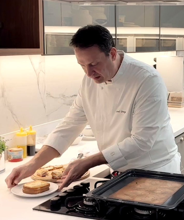 Chef Lionel Ortega em cozinha moderna servindo mini croques-monsieur em um prato branco