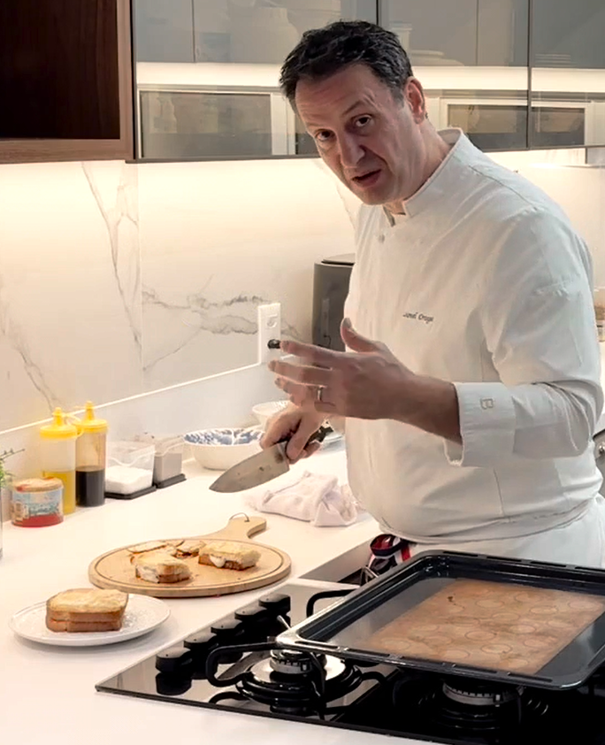 Chef Lionel Ortega em uma cozinha profissional preparando croques-monsieur